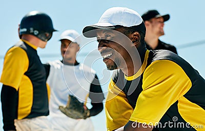 He lives for baseball. a handsome young baseball player smiling while kneeling on the field during the day. Stock Photo