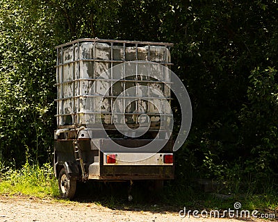 Livestock Water Tank on small trailer next to a hedgerow Stock Photo