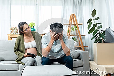 In a living room, Husband put your hands on his face and worry about financial problems because he just dismissed Stock Photo