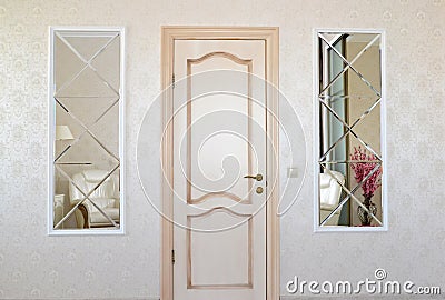 Living room wall with a door and two symmetric mirrors inserts Stock Photo