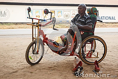 LIVINGSTONE - OCTOBER 14 2013: Local disabled man with an adapted wheelchair sets up successful shoe repair business in Editorial Stock Photo