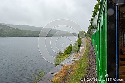 Llanberis Lake and Snowdonia mountains in the light rain seen from slow moving steam train - 2 Stock Photo