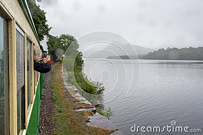 Llanberis Lake and Snowdonia mountains in the light rain seen from slow moving steam train - 1 Stock Photo