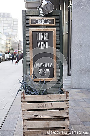 LLandudno, Wales, UK - MAY 27, 2018 Wooden black board outside the cafe. Large outdoor timings display of the resteraunt. Easle si Editorial Stock Photo