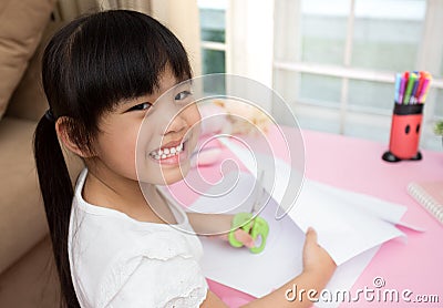 Llittle girl feeling happy doing cutting paper Stock Photo