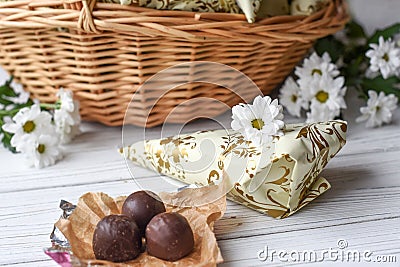 A llittle present, fresh flowers and some chocolate candies on a white wooden surface Stock Photo
