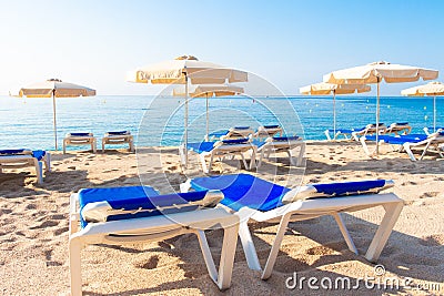 Lloret de Mar beach. Fenals platja. Umbrellas and chaise lounge Stock Photo