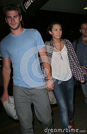 LMiley Cyrus & boyfriend Liam Hemsworth at LAX Editorial Stock Photo