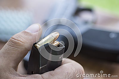 Load 9mm Ammo in the Pistol Clip Close Up. Hands, Bullets, Magazine and Handgun. Stock Photo