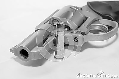 A loaded 357 stainless steel revolver with a hollow point bullet next to it Stock Photo