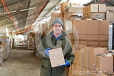 Loader stacks various boxes on racks in store Stock Photo