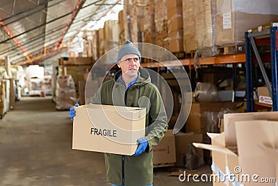 Loader stacks various boxes on racks in store Stock Photo