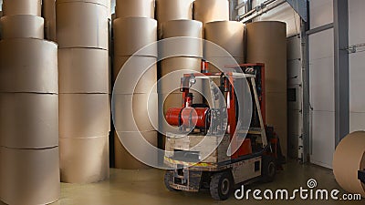 Old loader on the background of large rolls of newsprint Stock Photo