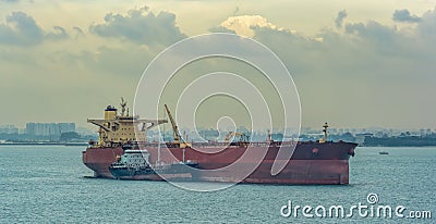 Loading anchored oil supertanker via a ship-to-ship oil transfer STS from raid tanker Stock Photo