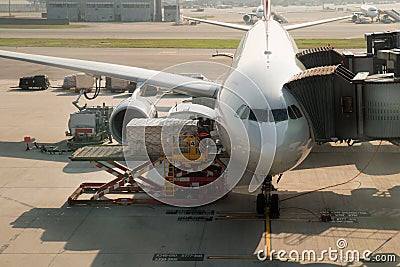 Loading cargo on plane in airport before flight. Editorial Stock Photo