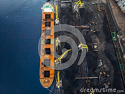 Loading coal Anthracite on bulk vessel ship in offshore cargo port. Aerial top view Stock Photo