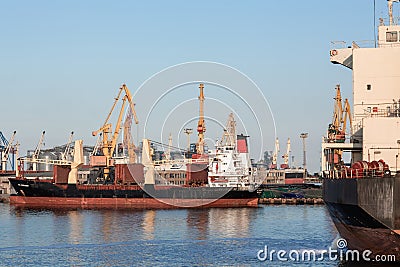 Loading containers on a container ships, port cranes and huge ships bottom up view. port container terminal Editorial Stock Photo