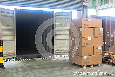 Loading shipment carton boxes and goods on wooden pallet at loading dock from container Stock Photo