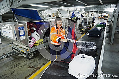 Loading and unloading operations and baggage control at the airport. Service for the transportation of belongings of aircraft Editorial Stock Photo