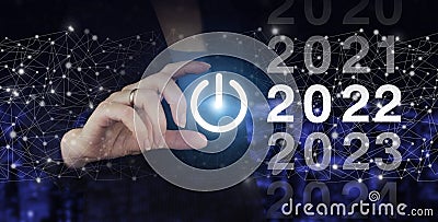 Loading year 2021 to 2022. Start concept. Hand hold digital hologram 2022 sign on city dark blurred background. Concept Start New Stock Photo