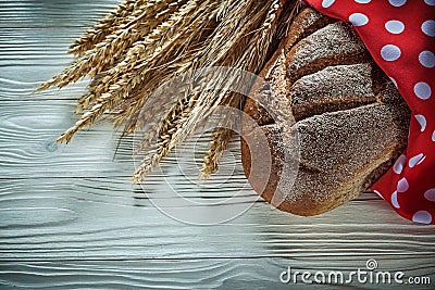 Loaf of bread rye ears red polka-dot tablecloth on white board Stock Photo