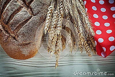 Loaf of bread wheat ears red polka-dot tablecloth on white board Stock Photo