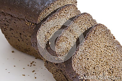 Loaf and slices of black bread on white background Stock Photo