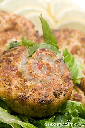 Lobster cakes bed of lettuce with lemon slice wedges Stock Photo