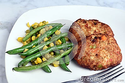 lobster cakes with sauteed green beans and vegetables Stock Photo