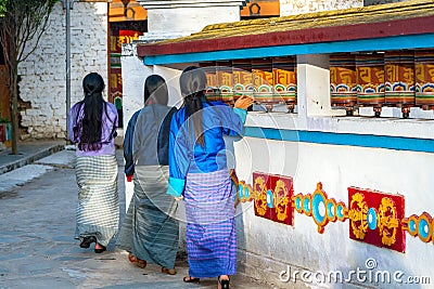 Local Bhutanese women turning prayer wheels - Bhutan Editorial Stock Photo