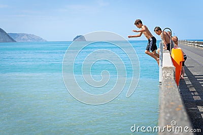 Local boys jumping of Tolaga Bay Wharf Editorial Stock Photo