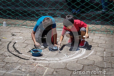 Local children making alfombra, sawdust carpets for Semana Santa, Easter on the street of Santiago Atitlan, Guatemala Editorial Stock Photo