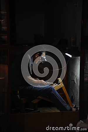 A local craftsman works in his tiny shop in Fez, Morocco. Editorial Stock Photo