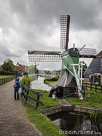 A local farmer tends his windmill in Zaansche Schans, Holland Editorial Stock Photo