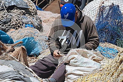 A local fisherman fixing his net in Essaouira, Morocco. Editorial Stock Photo