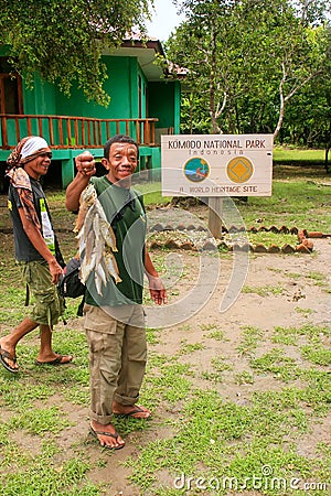 Local fisherman standing with fish by visitor center on Rinca Is Editorial Stock Photo