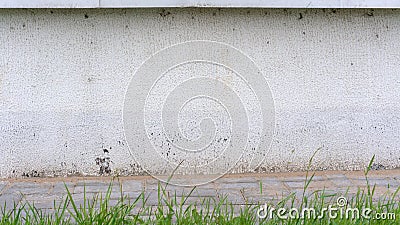 Local grey building wall near walkway with coloured pavement Stock Photo