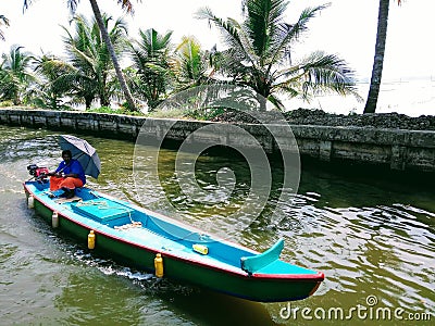 Local life of kerala Houseboat Alleppey Kerala India Alappuzha a man of kerala on wooden boat with umbrella Editorial Stock Photo