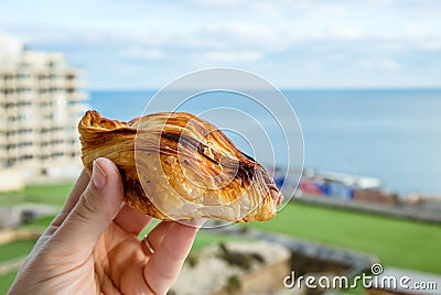 Local Maltese food called pastizz or pastizzi. Person hand holding Diamond-shaped small pie. Stock Photo