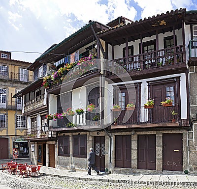 A local passes by the medieval buildings in the Santiago Square Editorial Stock Photo