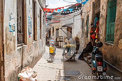 Local people on a street in Stone Town. Stone Town is the old part of Zanzibar City, the capital of Zanzibar, Tanzania Editorial Stock Photo