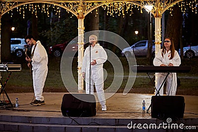 Local pop rock music band performs in gazebo of city public park, energetic outdoor performance Editorial Stock Photo