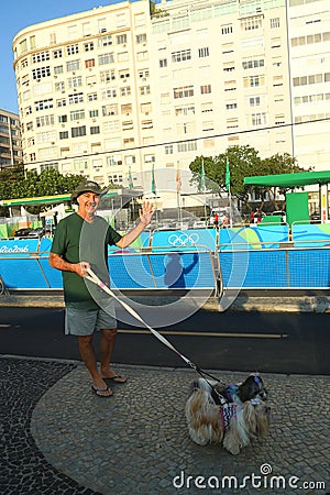 Local resident greeting athletes competing at Rio 2016 Olympic Cycling Road at Copacabana Beach Editorial Stock Photo