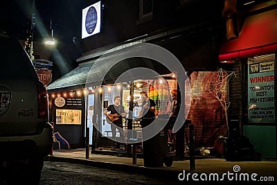 Local Toronto band playing on a corner store of Kensington Market. In a dark neighborhood, this band shines under the lit canopy. Editorial Stock Photo