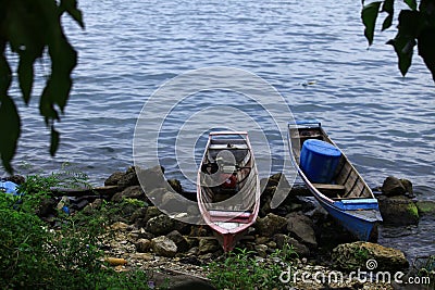 Boats of local fishers were harbored in the rocky beach in Toba Lake, North Sumatra, Indonesia Stock Photo