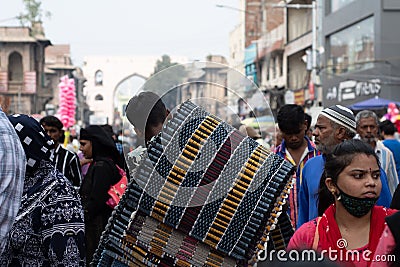 Local vendor carrying carpets on his back on a busy Charminar street Editorial Stock Photo