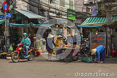 Local Vietnamese people walking on the street near Hoa Binh Market in Ho Chi Minh City, Vietnam Editorial Stock Photo