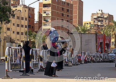 Local woman with her purchases in a bag balanced on her head leaving the market in the the Coptic Christian district of Cairo. Editorial Stock Photo