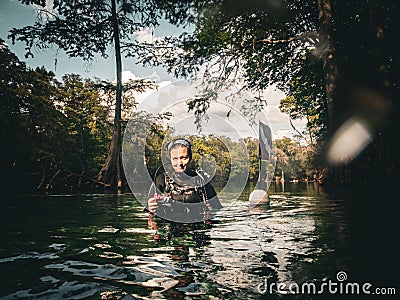 Local woman scuba diver tows dive flag down the Sante Fe River at Ginnie Springs, Florida Editorial Stock Photo