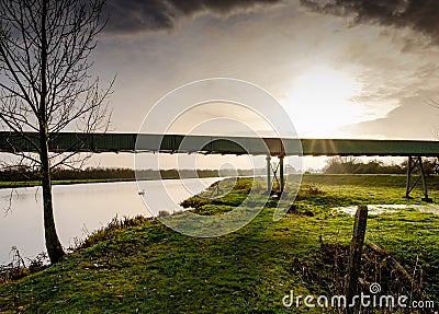 Localised flooding seen by a river bursting its banks after a spring tide. Stock Photo